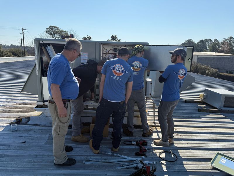 Five Air Support technicians servicing a commercial rooftop HVAC package unit