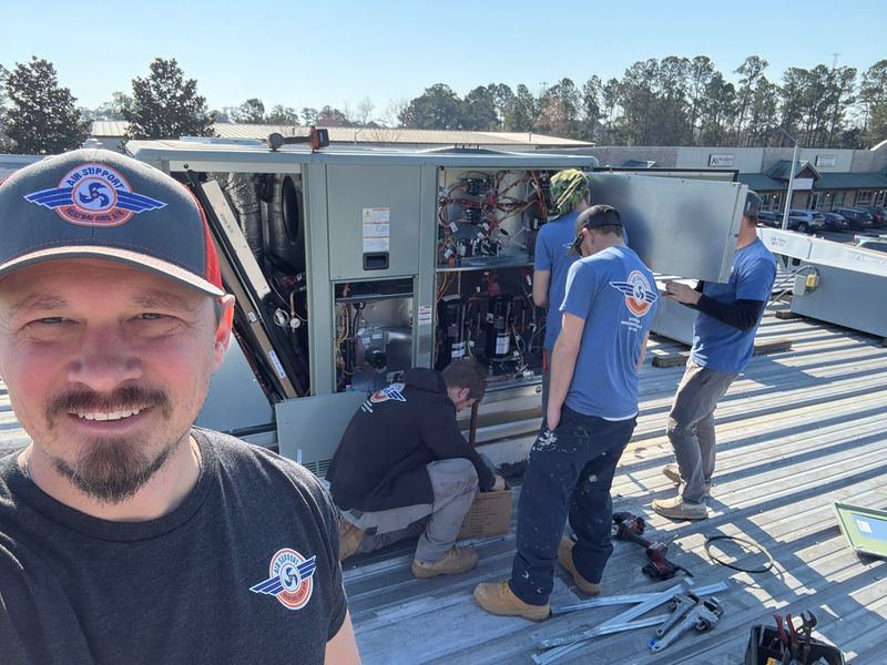 Air Support technician selfie with team working on commercial rooftop HVAC unit