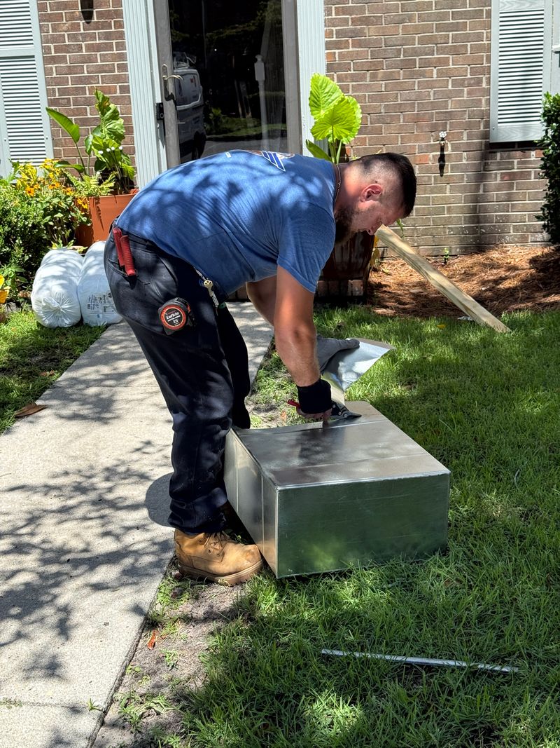 Air Support technician preparing a custom sheet metal plenum at a residential brick home