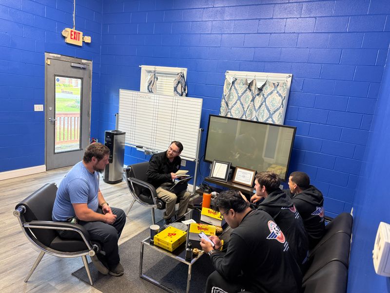 Air Support team members in a meeting at the company office with whiteboard and TV