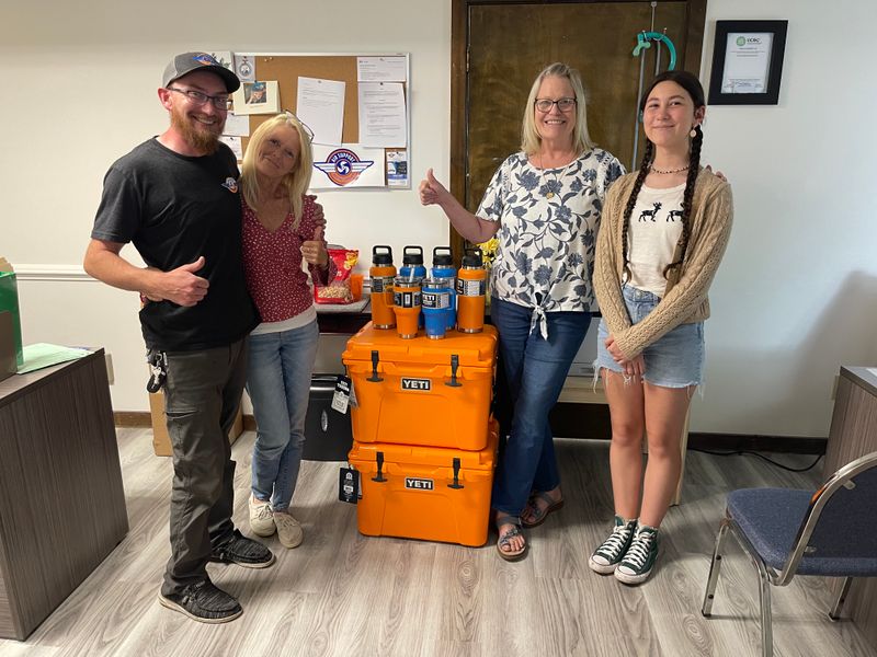 Air Support team members in office with branded orange Yeti coolers and drinkware