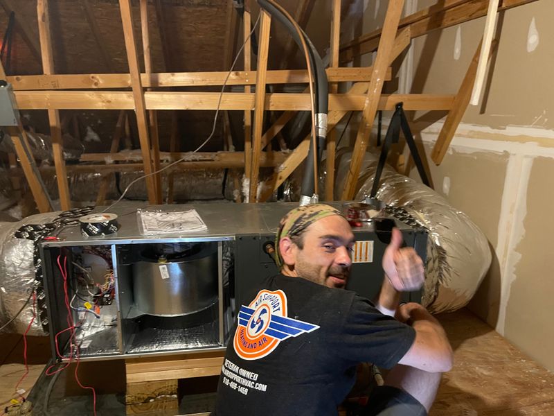 Air Support technician installing an air handler with blower motor visible in an attic