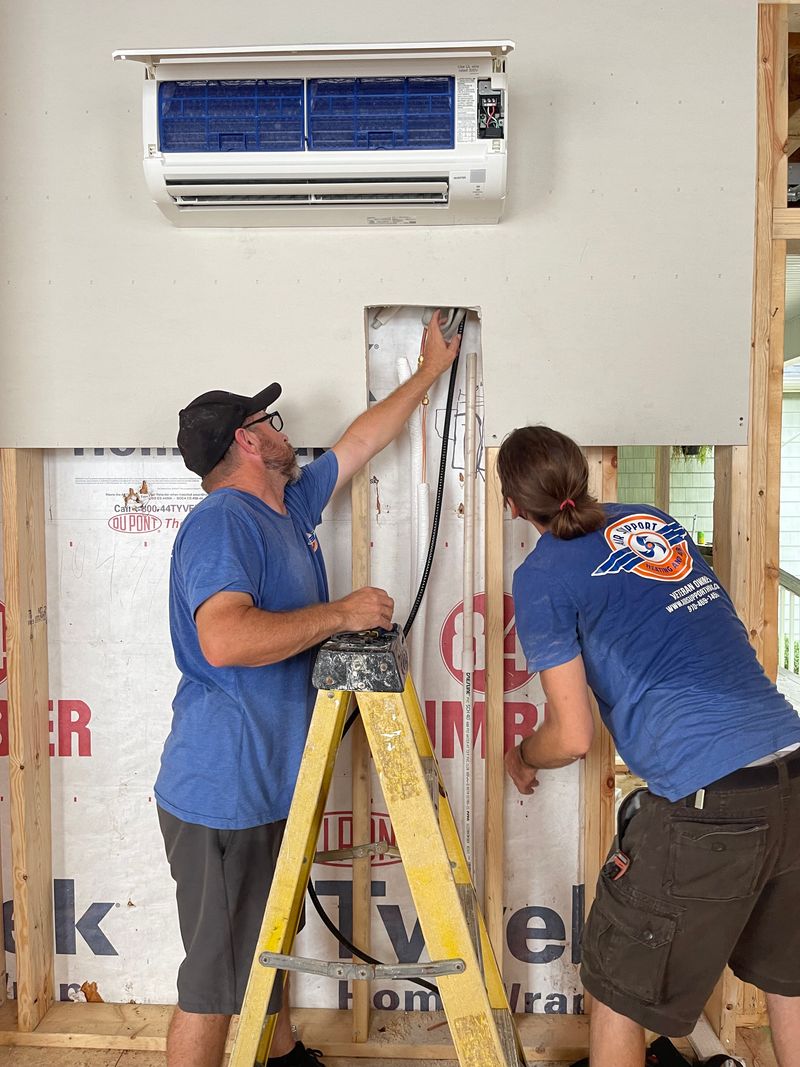 Two Air Support technicians running wiring for a ductless mini-split installation in new construction