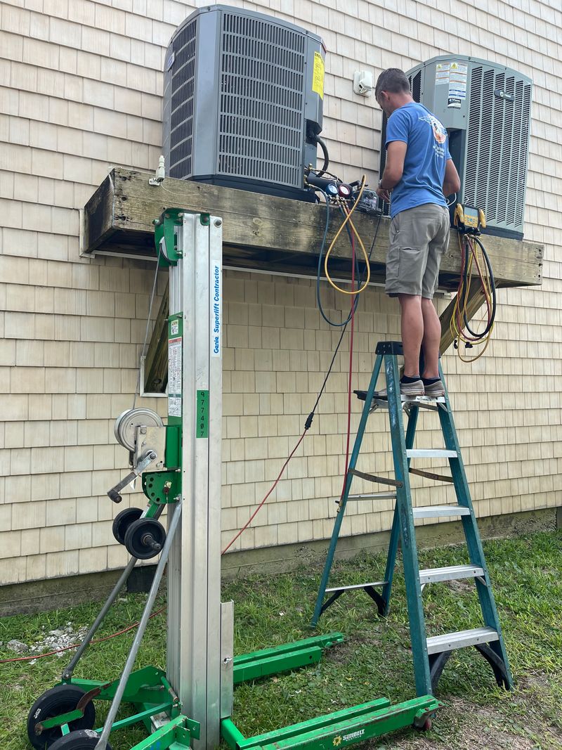 Air Support technician working on dual condenser units on an elevated deck platform