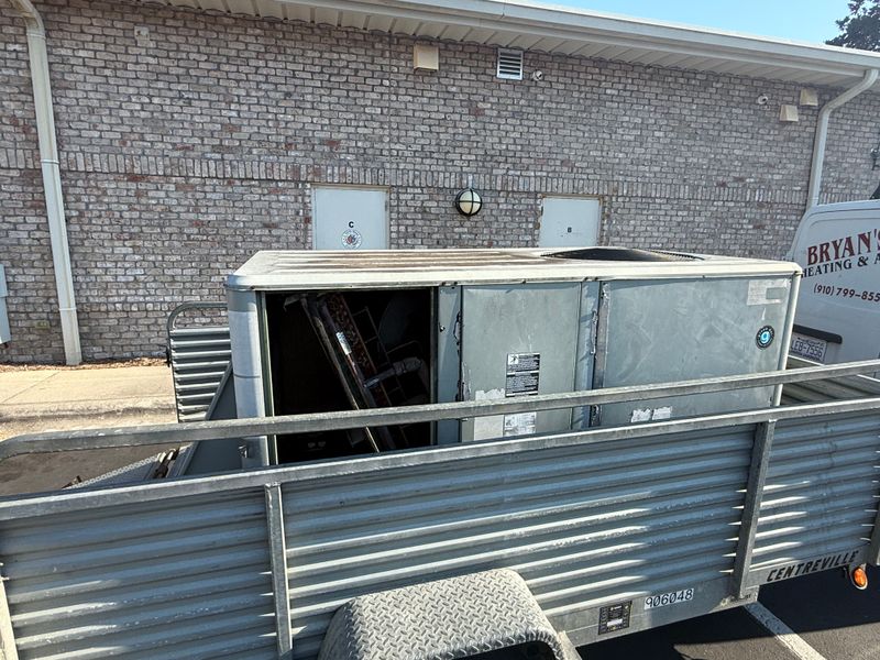 Old commercial HVAC package unit loaded on trailer for removal and replacement