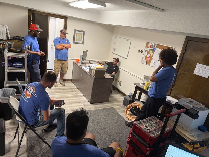 Air Support technicians in an office training session with copper tubing and tools